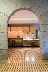 比索达雷加Original Douro Hotel的一个带厨房和桌子的房间的拱门