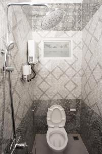 玛琅Huis Van Gustafine Floor 1的一间带卫生间的小浴室和墙上的照片