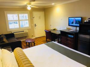 里弗赛德王朝套房酒店的客房设有一张床、一张书桌和电视