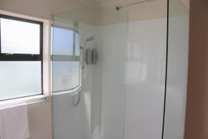 哈韦拉Kiwi Court Motel的带淋浴的浴室和玻璃门