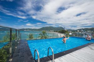 芭东海滩Patong Signature Boutique Hotel的男人和孩子在游泳池玩耍