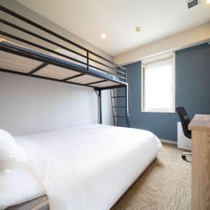 名户冲绳名护超级酒店 的一间卧室配有两张双层床和一张书桌