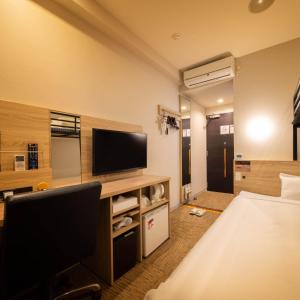 名户冲绳名护超级酒店 的配有一张床和一台平面电视的酒店客房