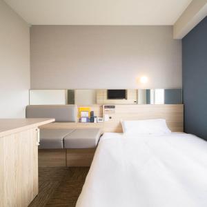 名户冲绳名护超级酒店 的一间卧室配有一张大床和一张书桌