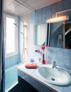 巴黎巴黎伏尔泰酒店的浴室配有盥洗盆、镜子和浴缸