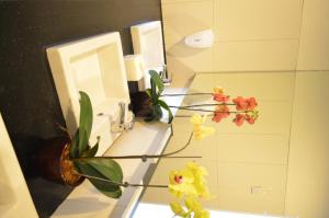 当格浪奇利亚雅加达机场酒店的浴室设有水槽、镜子和鲜花