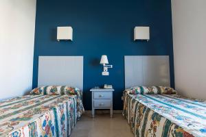 普韦布洛·纽沃·德·加德德拉戈旅馆的蓝色墙壁客房的两张床