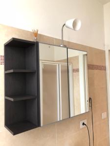 巴多利诺appartamenti vespucci 16的一间带镜子和灯的浴室