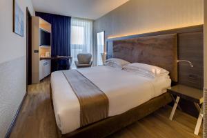 帕尔马法尔内塞加贝斯特韦斯特优质酒店的酒店客房设有一张大床和一张书桌。