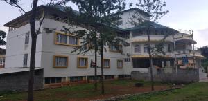 埃尔加德Casita inn,Yercaud的前面有树木的白色大建筑