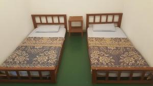 米里Tabun Homestay的绿地客房内的两张单人床