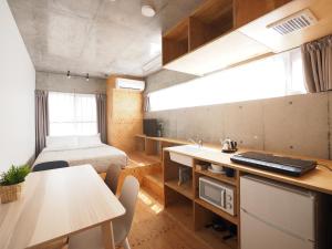 东京斯米莱押上之宿酒店的一间带一张床的房间和一间带桌子的厨房