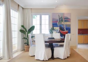 阿德耶Villas Espléndida的一间带桌子和白色椅子的用餐室