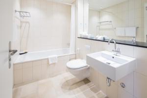 巴塞尔巴塞尔施维瑟酒店的浴室配有盥洗盆、卫生间和浴缸。