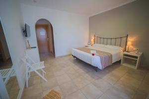 罗萨斯Casa Del Mar Hotel & Apartaments的卧室配有1张床、1张桌子和1把椅子