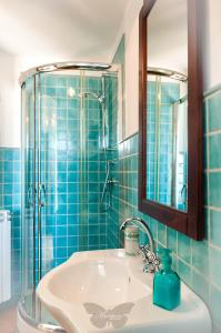 马拉泰亚B&B Mariposa的蓝色瓷砖浴室设有水槽和淋浴