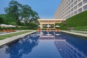 新德里新德里欧贝罗伊酒店的大楼前的游泳池