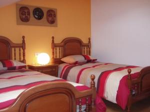 拉赫Ático nuevo en playa de Laxe的一间卧室设有两张床,墙上挂着一个时钟。