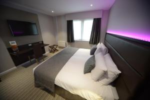杜伦 达拉谟班纳蒂尼酒店的酒店客房,配有一张紫色照明床