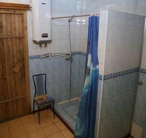 巴甫洛达尔мини-отель "Алатау"的带淋浴的浴室,旁边配有椅子