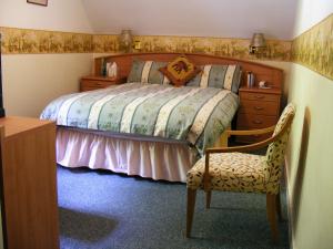 格伦芬南王子之家酒店的一间卧室配有一张床、梳妆台和椅子