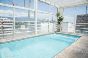 门多萨门多萨酒店 的一座大型游泳池,位于一座带窗户的建筑的顶部