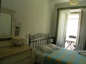 里斯本New Aljubarrota Guest House的一间卧室配有一张床、一个梳妆台和一扇窗户。