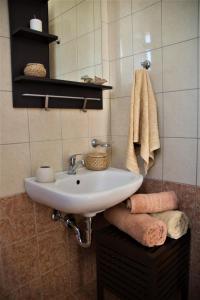 科斯镇Casa Verde Houses的浴室配有白色水槽和毛巾
