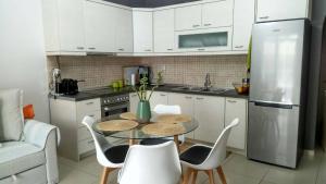 克拉默特Helios Apartment的厨房配有桌椅和冰箱。