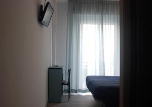 里乔内卡拉维拉酒店的一间卧室设有一张床和一个窗口