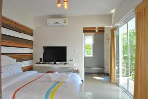 程逸府O.U.M. Hotel - โรงแรมโอยูเอ็ม的一间卧室配有一张床和一台平面电视