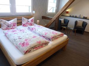 克罗夫Der Weinladen的一张带粉色和白色床单及枕头的床