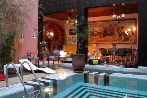 马拉喀什里亚德玛莉卡酒店的一个带椅子和桌子的大型游泳池