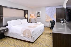 理查森Holiday Inn Dallas-Richardson, an IHG Hotel的酒店客房设有一张大床和一张书桌。