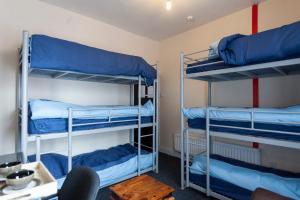 泰恩河畔纽卡斯尔Fenham Hotel express的客房设有三张双层床,配有蓝色床单
