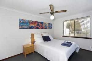珀斯Beachfront @ Scarbs的一间卧室配有一张床和吊扇