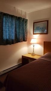 Oak PointHWY6HOTEL的一间卧室配有一张床和一张桌子上的台灯
