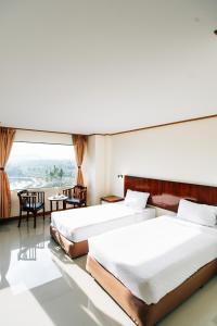 沙敦辛凯塔尼酒店的配有大窗户的酒店客房内的两张床