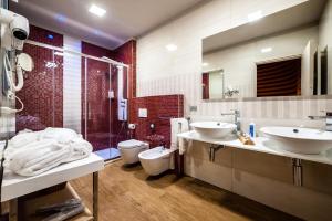 Caramagna PiemonteHotel Terre Dei Salici的一间带两个盥洗盆、淋浴和卫生间的浴室