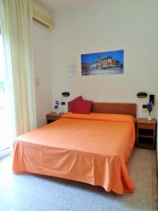 里米尼Hotel Lariana的一间卧室配有一张带橙色床罩的床