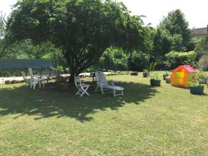 沙尼勃艮第恩罗兰别墅度假屋的院子树下两把椅子和一张桌子