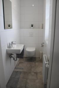 OberlangenHaus Kornblume的白色的浴室设有水槽和卫生间。