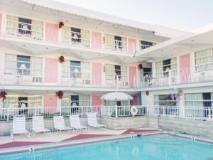 怀尔德伍德粉红香槟汽车旅馆的大楼前设有游泳池的酒店