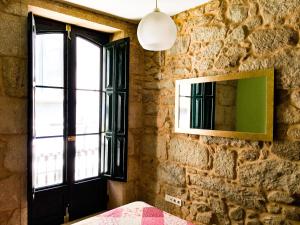 帕德隆Santiaguiño 2的一间卧室设有石墙、窗户和镜子