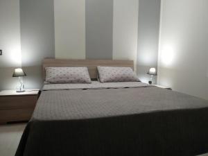 墨西拿Via Roma 12的一间卧室配有一张大床和两盏灯