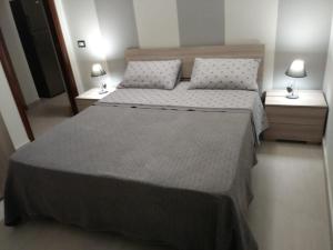 墨西拿Via Roma 12的一间卧室设有两张床和两个床头柜