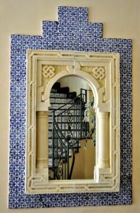 圣维托罗卡波安泰尔酒店的一面墙上的镜子,上面有蓝色和白色的瓷砖