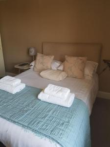 阿什伯恩乔治和龙阿什伯恩旅馆的床上配有毛巾和枕头