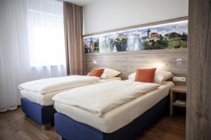 库姆巴赫埃尔特酒店的两张位于酒店客房的床,墙上挂着一幅画