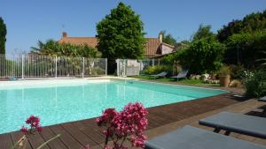 Mouilleron-en-Pareds拉布瓦尼耶尔住宿加早餐旅馆的一座鲜花盛开的庭院内的游泳池